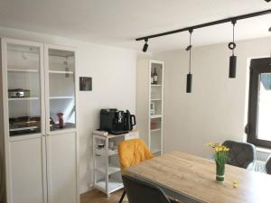 a room with a table and chairs and a kitchen at Schicke hundefreundliche Wohnung in Alsheim