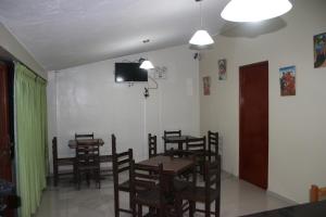 a dining room with tables and chairs and a tv on the wall at Pachamama Hostel in Cusco