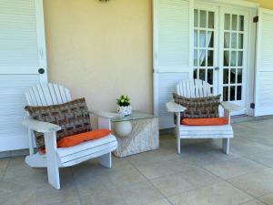 two chairs and a table on a porch at Sugarfields Garden Villa in Jolly Harbour