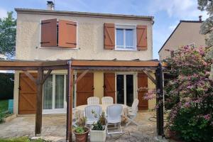 a patio with a table and chairs in front of a house at Un Havre de Paix in Villepinte