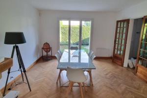 a dining room with a glass table and chairs at Un Havre de Paix in Villepinte +30 photos