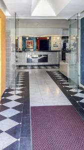 a large kitchen with glass walls and a tile floor at Hotel Soraya in Lignano Sabbiadoro