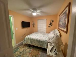 a bedroom with a bed and a flat screen tv at Nw Condo Steps To Beach Overlooking Pool & Ocean in North Wildwood
