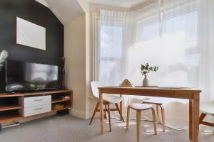 a dining room with a table and a television at Central Exeter's Perfect 2 BR Flat in Exeter
