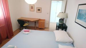 um quarto com uma cama, uma secretária e uma mesa em Apartmani ANDRIJA em Živogošće