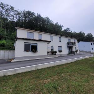 a white building with windows on the side of a road at Apartma Uhanje pri Božičevih in Ajdovščina