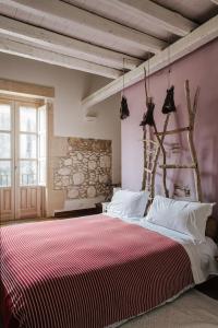 a bedroom with a large bed with a red and white blanket at B&B Palazzo Del Sale in Siracusa