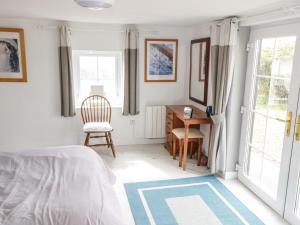 a bedroom with a bed and a desk and a chair at Sound Cottage in Sraheens