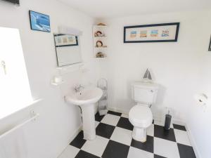 a bathroom with a white toilet and a sink at Sound Cottage in Sraheens +18 photos