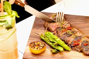 a person cutting a piece of meat with a knife and fork at Soho Grand Hotel in New York