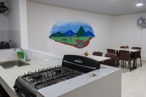 a kitchen with a stove with a picture on the wall at Los Nonos Hostel in Guadalupe