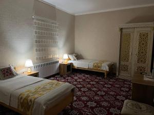 Habitación de hotel con 2 camas y 2 lámparas en SAID-MAXSUM en Khiva