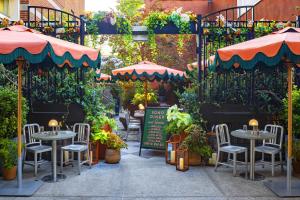 a patio with tables and umbrellas and plants at Soho Grand Hotel in New York