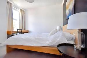 a bedroom with a bed with a table and a window at Central Exeter's Perfect 2 BR Flat in Exeter
