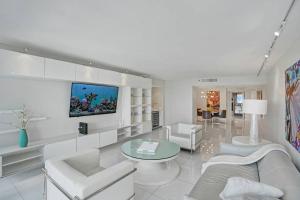 sala de estar con muebles blancos y TV de pantalla plana en Seas The Day! Complete Panoramic Water Views, en Miami