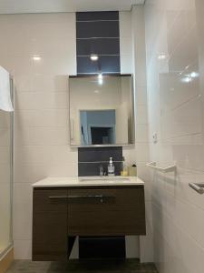 ein Badezimmer mit Waschbecken und Spiegel in der Unterkunft Apartment São MARTINHO - Aveiro in Aveiro + 5 Fotos