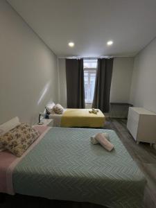 ein Schlafzimmer mit zwei Betten und einem Fenster in der Unterkunft Apartment São MARTINHO - Aveiro in Aveiro