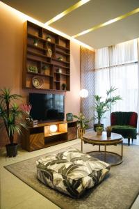 a living room with a tv and a couch and a table at Nakheel Residence Sabah Alsalem by House living in Kuwait