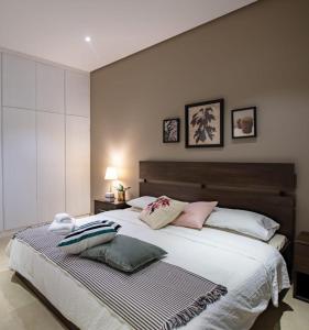 a bedroom with a large bed with pillows on it at Nakheel Residence Sabah Alsalem by House living in Kuwait