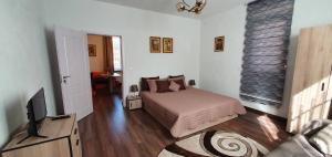 a bedroom with a bed and a flat screen tv at АПАРТАМЕНТ ЮЛИЯ ДЕЛУКС I in Velingrad