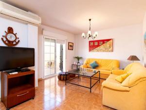 a living room with a yellow couch and a tv at Casa del Sol in Salobreña