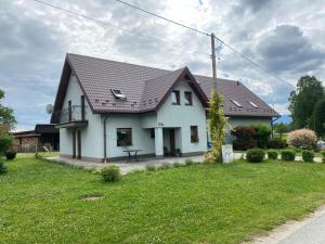 a white house with a black roof at Nad Wilczym Potokiem in Miedzygorze
