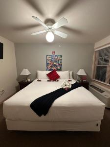 um quarto com uma grande cama branca e uma ventoinha de tecto em Mill Creek Hotel em Lake Geneva