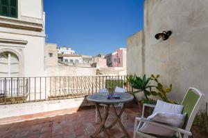 a patio with a table and chairs on a balcony at B&B Palazzo Del Sale in Syracuse