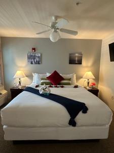 a bedroom with a large white bed with two lamps at Mill Creek Hotel in Lake Geneva