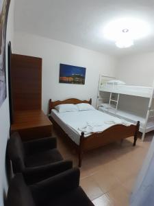 een slaapkamer met een bed, een stoel en een trap bij Cozy apartment in the city center 2 in Shkodër
