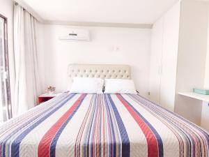 a bedroom with a bed with a colorful striped blanket at Hospedagem Stein - Suíte 402 in Domingos Martins