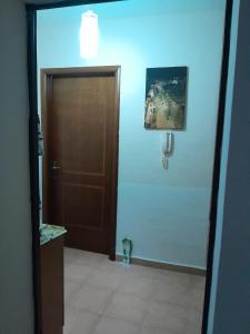 een badkamer met een bruine deur en een tegelvloer bij Cozy apartment in the city center 2 in Shkodër