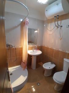 een badkamer met een toilet, een wastafel en een douche bij Cozy apartment in the city center 2 in Shkodër