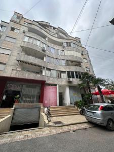 een gebouw waar een auto voor geparkeerd staat bij Cozy apartment in the city center 2 in Shkodër