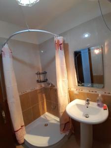 een badkamer met een wastafel, een douche en een spiegel bij Cozy apartment in the city center 2 in Shkodër