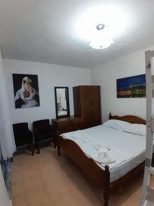 een slaapkamer met een bed en 2 stoelen. bij Cozy apartment in the city center 2 in Shkodër
