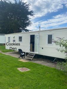 Ein weißer Wohnwagen mit einem Schild, auf dem Kekse in der Nähe stehen. in der Unterkunft Cookies Den in Weymouth