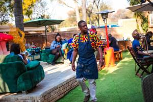 a man is walking on the grass in a yard at Menlyn Mews BnB in Pretoria