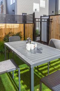 a picnic table with two mugs on top of it at Modern Townhouse Cashel Street 2 bed 2 bath in Christchurch