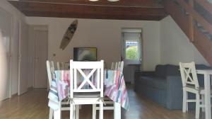 a living room with a table and chairs and a couch at Villa duplex Soustons plage, in Soustons