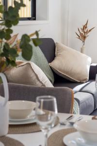 ein Wohnzimmer mit einem Sofa und einem Tisch mit Brille in der Unterkunft Modern Townhouse Cashel Street 2 bed 2 bath in Christchurch