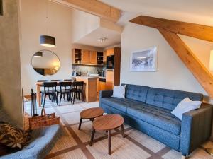 ein Wohnzimmer mit einer blauen Couch und einer Küche in der Unterkunft Appartement 3 pièces avec cheminée, accès pistes, piscine, spa, WIFI - Flaine Montsoleil - FR-1-425-140 in Flaine