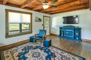 ein Wohnzimmer mit einem blauen Stuhl und einem TV in der Unterkunft Secluded Campton Cabin with Views and Cozy Fireplace! in Campton