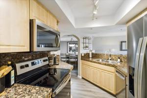 a kitchen with wooden cabinets and granite counter tops at Biltmore Bliss: Desert Retreat! in Phoenix