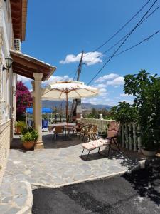 a patio with a table and chairs and an umbrella at Venta Judio in Purchena