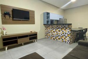sala de estar con TV de pantalla plana en la pared en Casa Completa com 2 Quartos e Garagem en Marabá