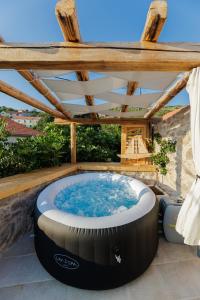 a hot tub on a patio with a wooden roof at Villa Teza Hvar in Hvar