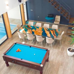 a pool table in the middle of a room at Villa du Belvédère, piscine intérieure, spa et hammam in Montagnac