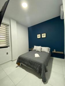 1 dormitorio con 1 cama con pared azul en Depas Mololoa, en Tepic