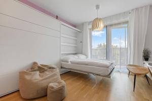 a white bedroom with a bed and a window at LAM Lavender with Free Parking in Bratislava